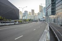 an empty freeway leading to a large city with tall buildings in the background / by richard _ c