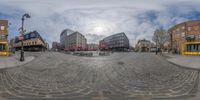 a circular picture of a street in the middle of the city at day time with no one sitting on the sidewalk