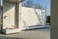 an outdoor area with large tile wall and a planter and a bench underneath the entrance