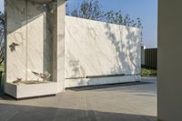 an outdoor area with large tile wall and a planter and a bench underneath the entrance