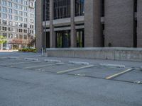 a street with a building near the building in the middle and on the left of which is a parking lot, as shown in this photo