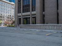 a street with a building near the building in the middle and on the left of which is a parking lot, as shown in this photo