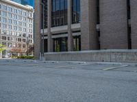 a street with a building near the building in the middle and on the left of which is a parking lot, as shown in this photo