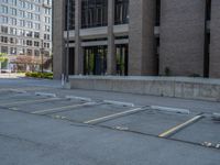 a street with a building near the building in the middle and on the left of which is a parking lot, as shown in this photo