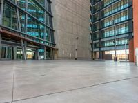 a skateboarder doing tricks on the sidewalk in front of a very tall building