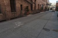 a brick building with an iron railing next to a sidewalk that leads into a building with brown brick walls