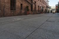 a brick building with an iron railing next to a sidewalk that leads into a building with brown brick walls