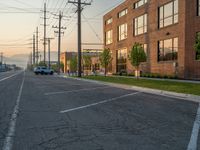 an empty street in front of a large red brick building on the other side of the road is a street light that has a line for motorists