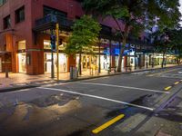 a street with a bus stoplight and a storefront with its lights on at night