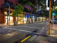 a street with a bus stoplight and a storefront with its lights on at night