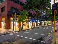 a street with a bus stoplight and a storefront with its lights on at night