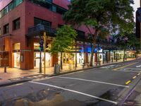 a street with a bus stoplight and a storefront with its lights on at night