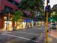 a street with a bus stoplight and a storefront with its lights on at night