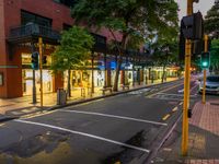 a street with a bus stoplight and a storefront with its lights on at night