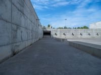 the empty parking lot in front of a wall with apartment buildings on it and a skateboarder on a ramp