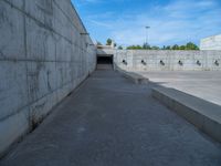 the empty parking lot in front of a wall with apartment buildings on it and a skateboarder on a ramp