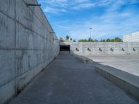 the empty parking lot in front of a wall with apartment buildings on it and a skateboarder on a ramp