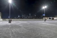 a parking lot in front of city lights at night with a view over the city