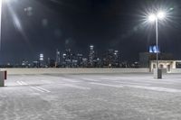 a parking lot in front of city lights at night with a view over the city