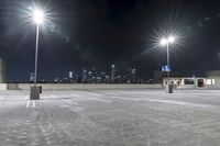 a parking lot in front of city lights at night with a view over the city