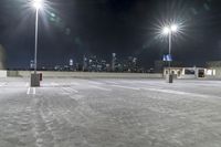 a parking lot in front of city lights at night with a view over the city