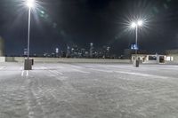 a parking lot in front of city lights at night with a view over the city