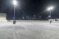 a parking lot in front of city lights at night with a view over the city