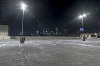 a parking lot in front of city lights at night with a view over the city