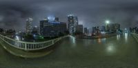 a fish eye shot taken from a bridge in front of tall buildings in a city