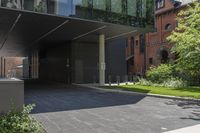 this is an outside building with a building in the background and trees growing on the curb