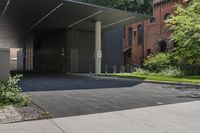 this is an outside building with a building in the background and trees growing on the curb