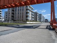 a long dock with concrete bricks beside a marina area with orange structures and buildings on the other side