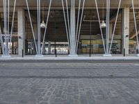 this is a large building with metal pipes on the front and floors, and a sidewalk in front