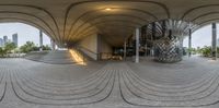 a building with an outdoor walkway in front of it and two spiral designs on the ground