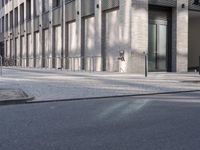 a sidewalk near a building with an umbrella near by in the sunlight at dusk with sunlight streaming in the windows