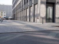 a sidewalk near a building with an umbrella near by in the sunlight at dusk with sunlight streaming in the windows