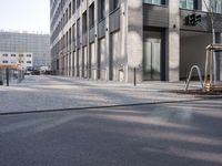 a sidewalk near a building with an umbrella near by in the sunlight at dusk with sunlight streaming in the windows