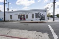 a large white building that has graffiti on it on the side of the road in a city