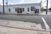 a large white building that has graffiti on it on the side of the road in a city