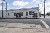 a large white building that has graffiti on it on the side of the road in a city