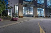 a night time shot of a city street in canada with the lights on and large windows