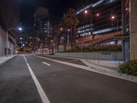 night time traffic and lights on the street of a city with tall buildings in the background