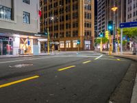 a corner in the middle of a city street at night with a traffic light in the foreground