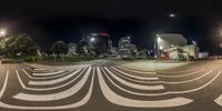 an intersection in a city at night with an empty street and several buildings in the background