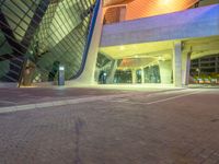 a parking space at night with light and windows lit up in the background and a car in the foreground