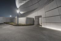 a building with concrete on both sides and an outside area in front of it in a shadow