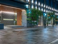 a large brick sidewalk with a store front at night time and a sign that says