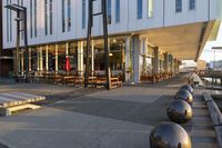 a long table and benches in front of a big building, with windows on each side