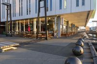 a long table and benches in front of a big building, with windows on each side