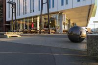 a long table and benches in front of a big building, with windows on each side